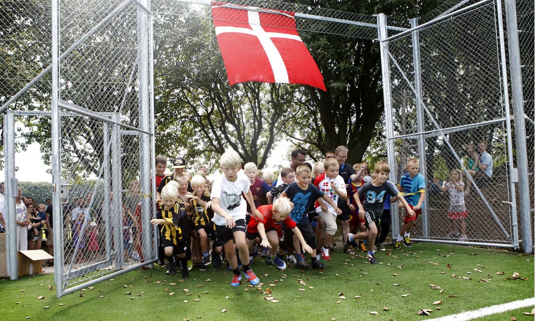 Børn strømmer ind, da en ny kunstgræsbane åbner i det nordlige Aarhus. Efter træningen slæbte børnene sandsynligvis kilovis af små stykker gummigranulat med hjem og ud i resten af byen. Det er ikke sundhedsfarligt at spille på, men det kan få miljømæssige konsekvenser, hvis gummiet havner som mikroplast i naturen.