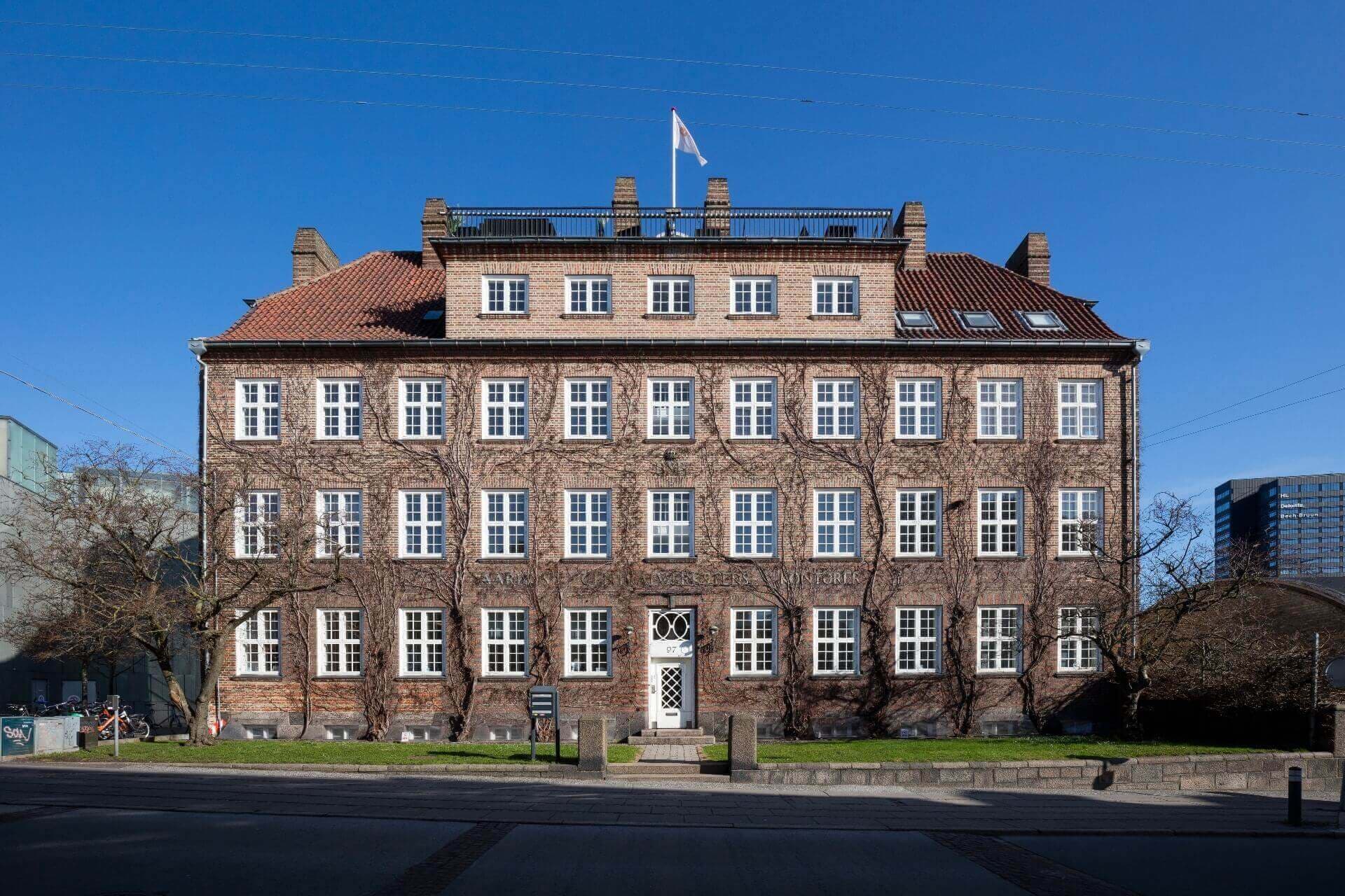 Den Gamle By i Aarhus er kendt for at bevare historiske huse fra en svunden tid. Men i resten af byen får Aarhus kritik for at være for hurtig til at tillade nedrivninger til fordel for nybyggeri. Her ses Baumannhuset fra 1910. Bygningen er nu fredet. Den blev ombygget og restaureret i 2006. De to nederste etager rummer DGI-husets spinning- og fitnessområde.
