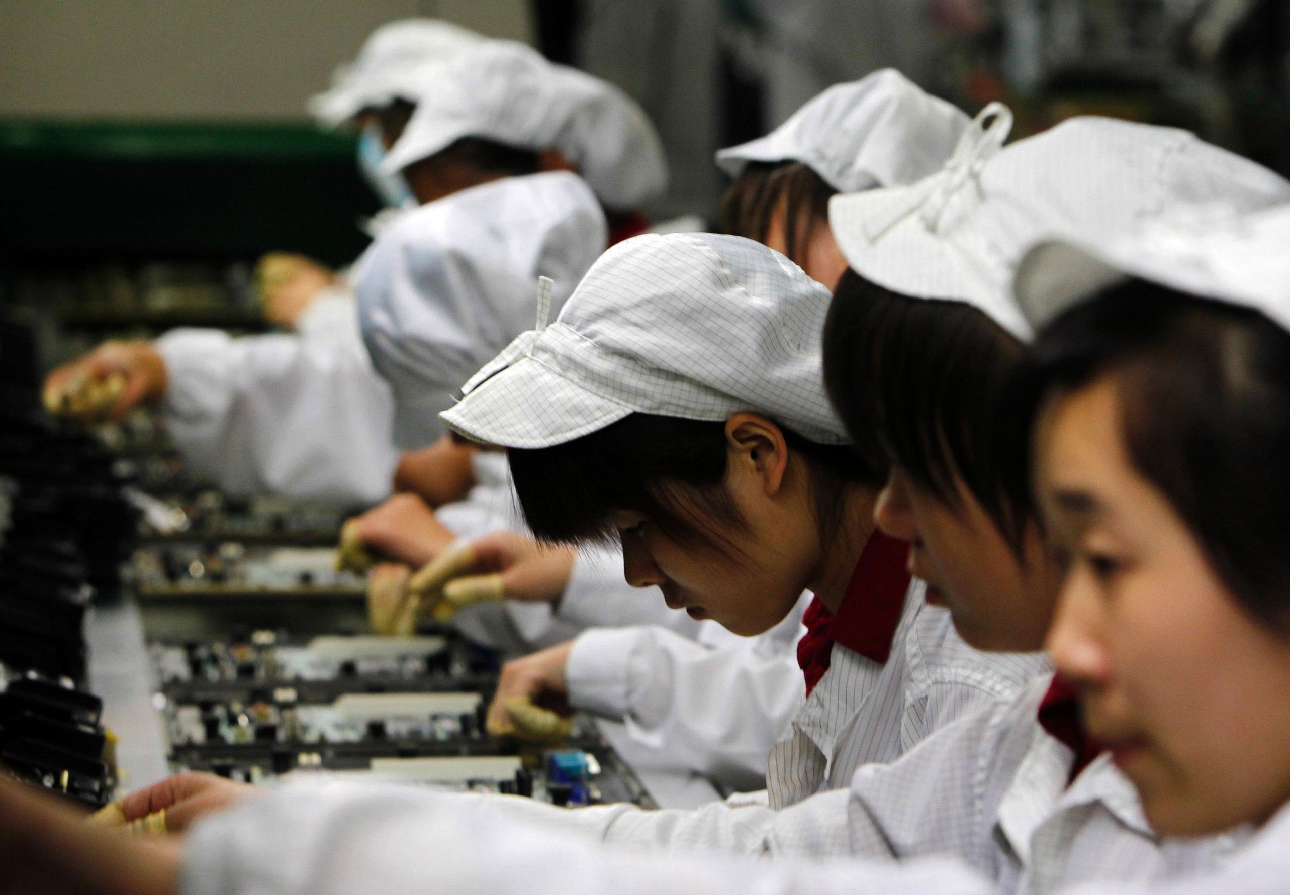 Kinesiske arbejdere samler computere på en fabrik i Shenzhen, hvor flere underleverandører til mærker som Dell og Apple har til huse. Arbejdsforholdene på de kinesiske elektronikfabrikker
kom senest i fokus efter en stribe selvmord blandt arbejdere hos Foxconn Electronics, en af branchens største underleverandører. Foto: Polfoto