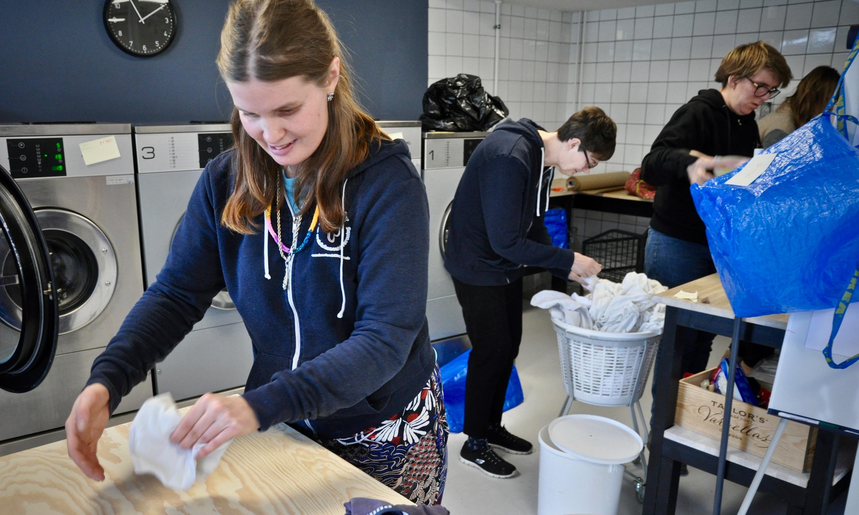 I Vaskeriet vasker Katja Sønderbek på billedet både tøj til private og virksomheder. En af kunderne er shawarmabaren, som er Vaskeriets nabo.