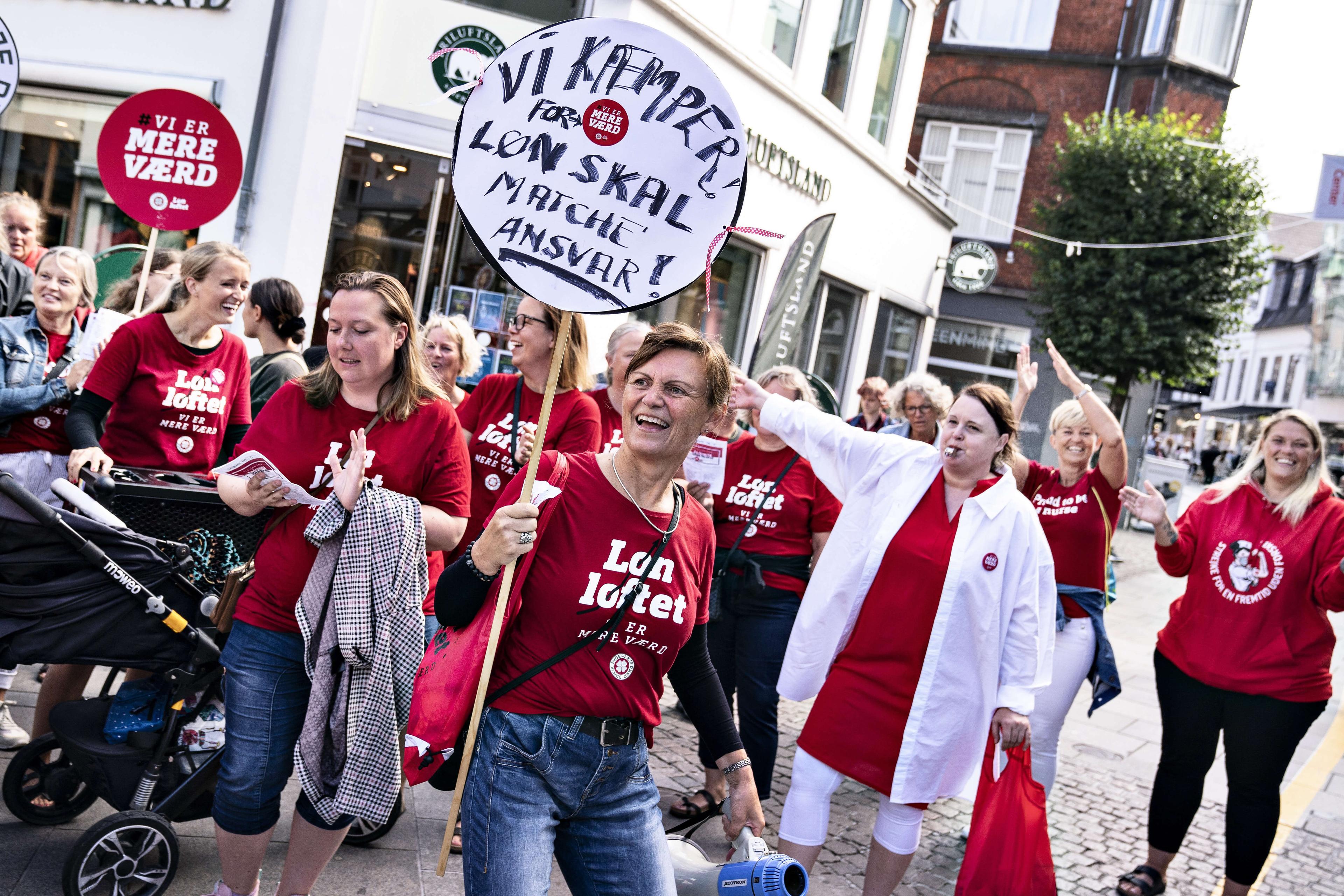 Sygeplejersker i strejke demonstrerer i Aalborgs midtby fredag den 30. juli - strejken trækker ud og udvides i næste måned. Nu kan den ende med at blive den længste i nyere tid.