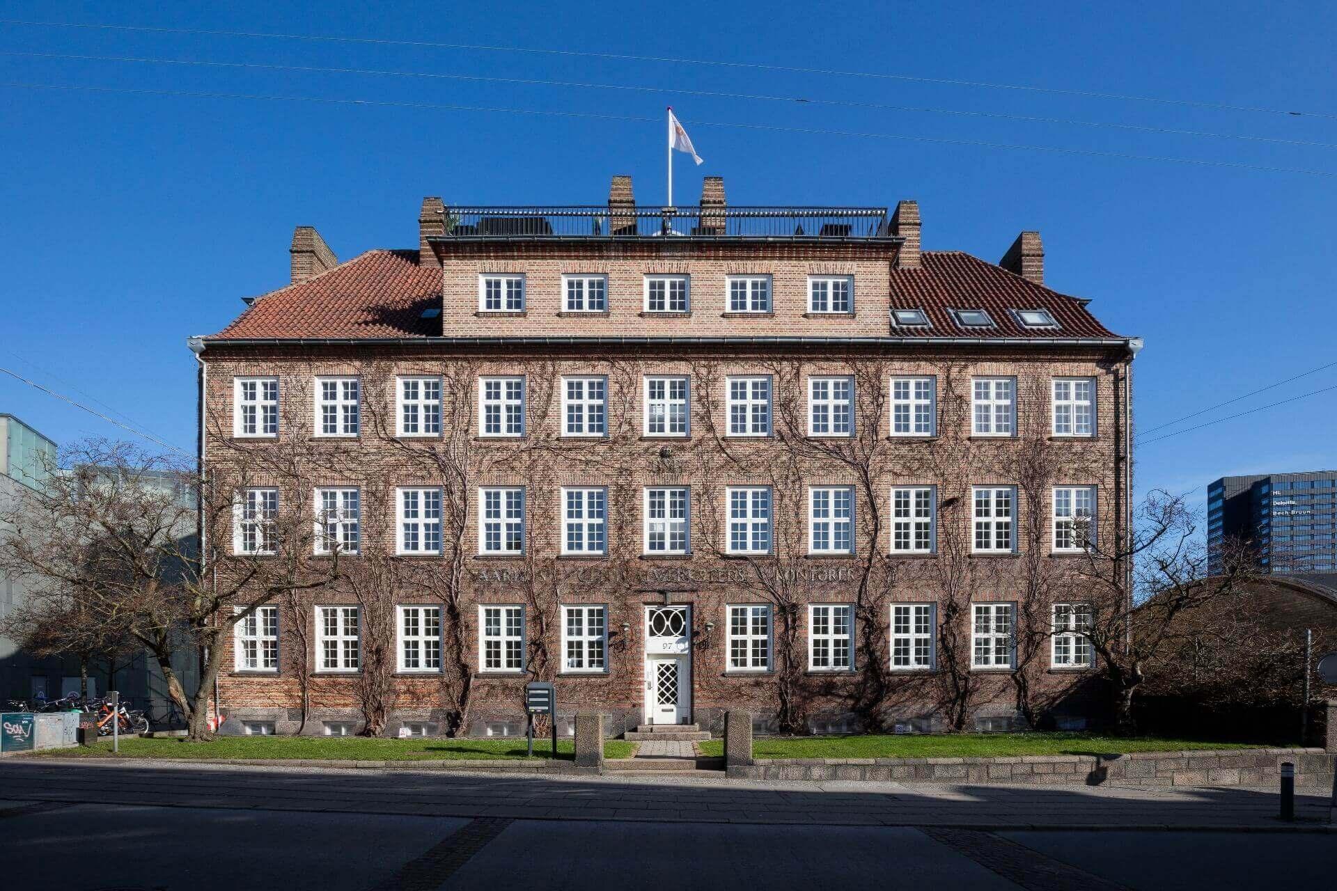 Den Gamle By i Aarhus er kendt for at bevare historiske huse fra en svunden tid. Men i resten af byen får Aarhus kritik for at være for hurtig til at tillade nedrivninger til fordel for nybyggeri. Her ses Baumannhuset fra 1910. Bygningen er nu fredet. Den blev ombygget og restaureret i 2006. De to nederste etager rummer DGI-husets spinning- og fitnessområde.

