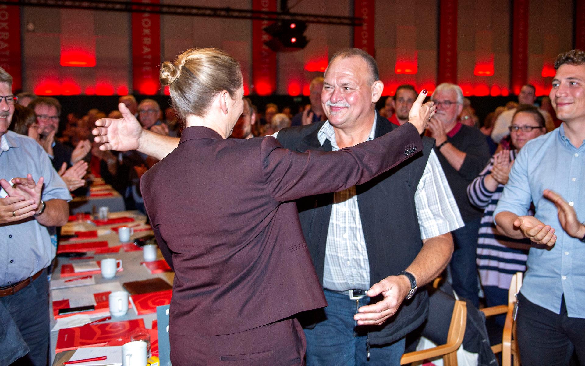 Statsminister Mette Frederiksen (S) hilser på Arne Juhl, der blev ansigtet på kampagnen for Arne-pensionen, efter sin tale ved Socialdemokratiets kongres i 2019.